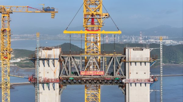 金港赢配资 世界最大跨海悬索桥主塔实现上横梁“云端合龙”